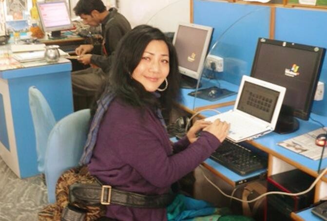图为印度女孩在网吧蹭网已完成自己的工作。
