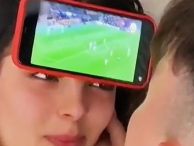 足球与女友兼顾 外国一男子将手机粘在女友额头 进球就狂吻女友