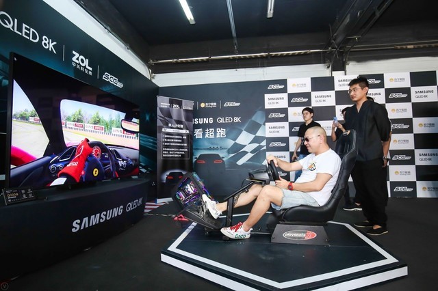 scc创始人宽宽在体验区通过三星qled 8k电视体验赛车游戏