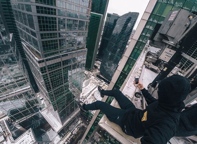 外国小哥下雪天无安全措施爬楼顶拍照